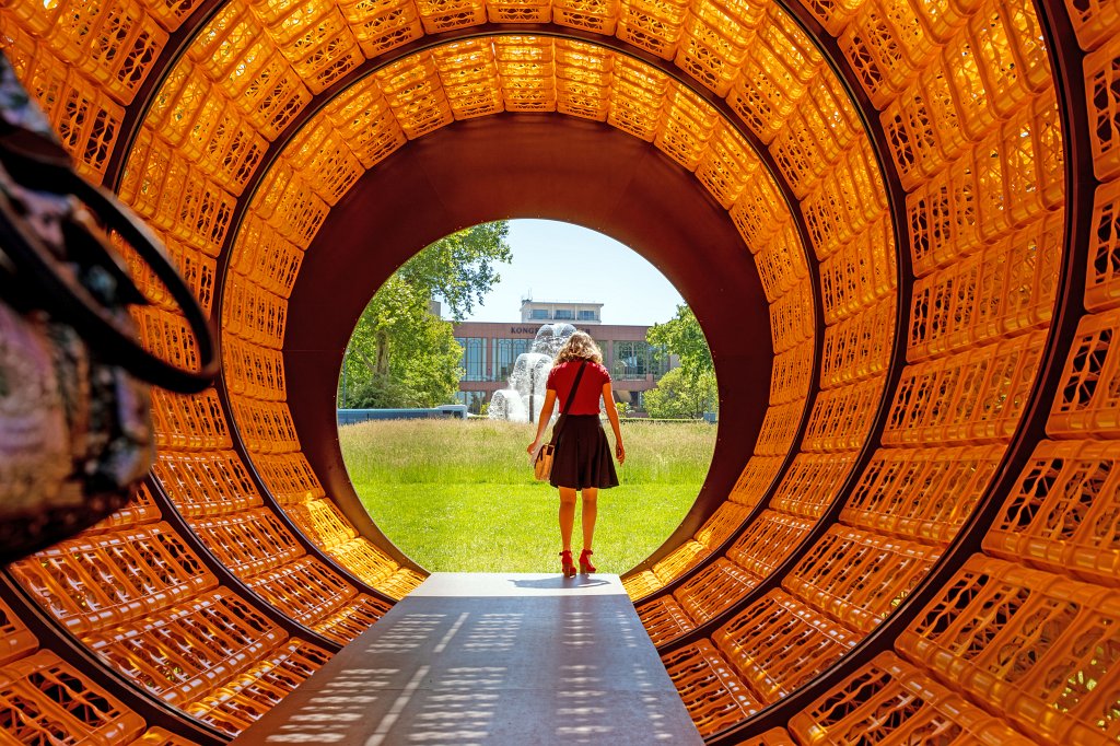 574B9903_c.jpg - Donnerstags ist alles gut - Wolfgang Winter und Berthold Hörbelt - Blickachsen 12 - Bad Homburg 2019.This piece of art is a 11m long tube made out of 900 yellow bottle crates. This is fun if you are inside with the sun light creating patterns and the view to the fountains on both sides.