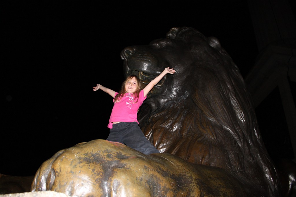 IMG_2478.JPG - Naomi on Trafalgar Square Lion  http://en.wikipedia.org/wiki/Trafalgar_Square 
