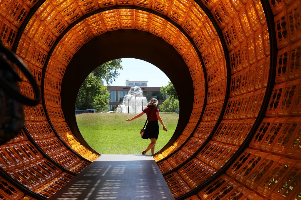 574B9904.JPG - Donnerstags ist alles gut - Wolfgang Winter und Berthold Hörbelt - Blickachsen 12 - Bad Homburg 2019.This piece of art is a 11m long tube made out of 900 yellow bottle crates. This is fun if you are inside with the sun light creating patterns and the view to the fountains on both sides.