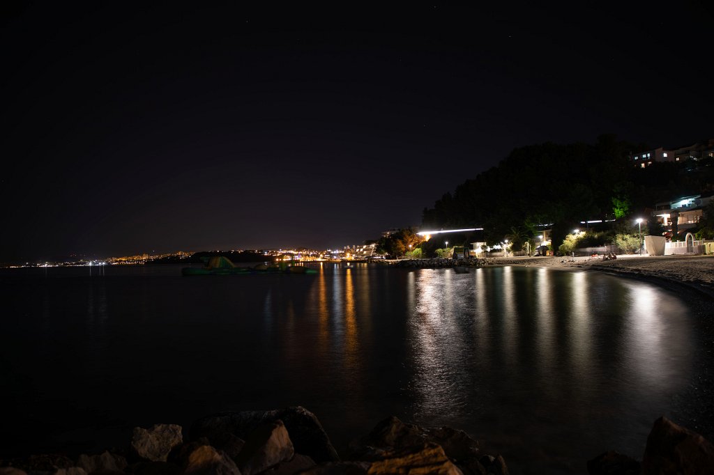 574B1978_c.jpg - Beach at night featuring the lights of Split as background